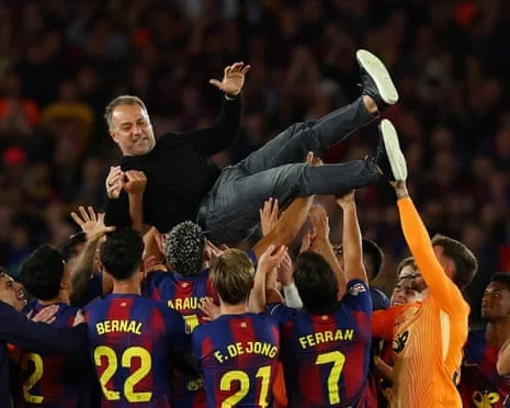 Barcelona players throw coach Hansi Flick in the air as they celebrate after winning La Liga